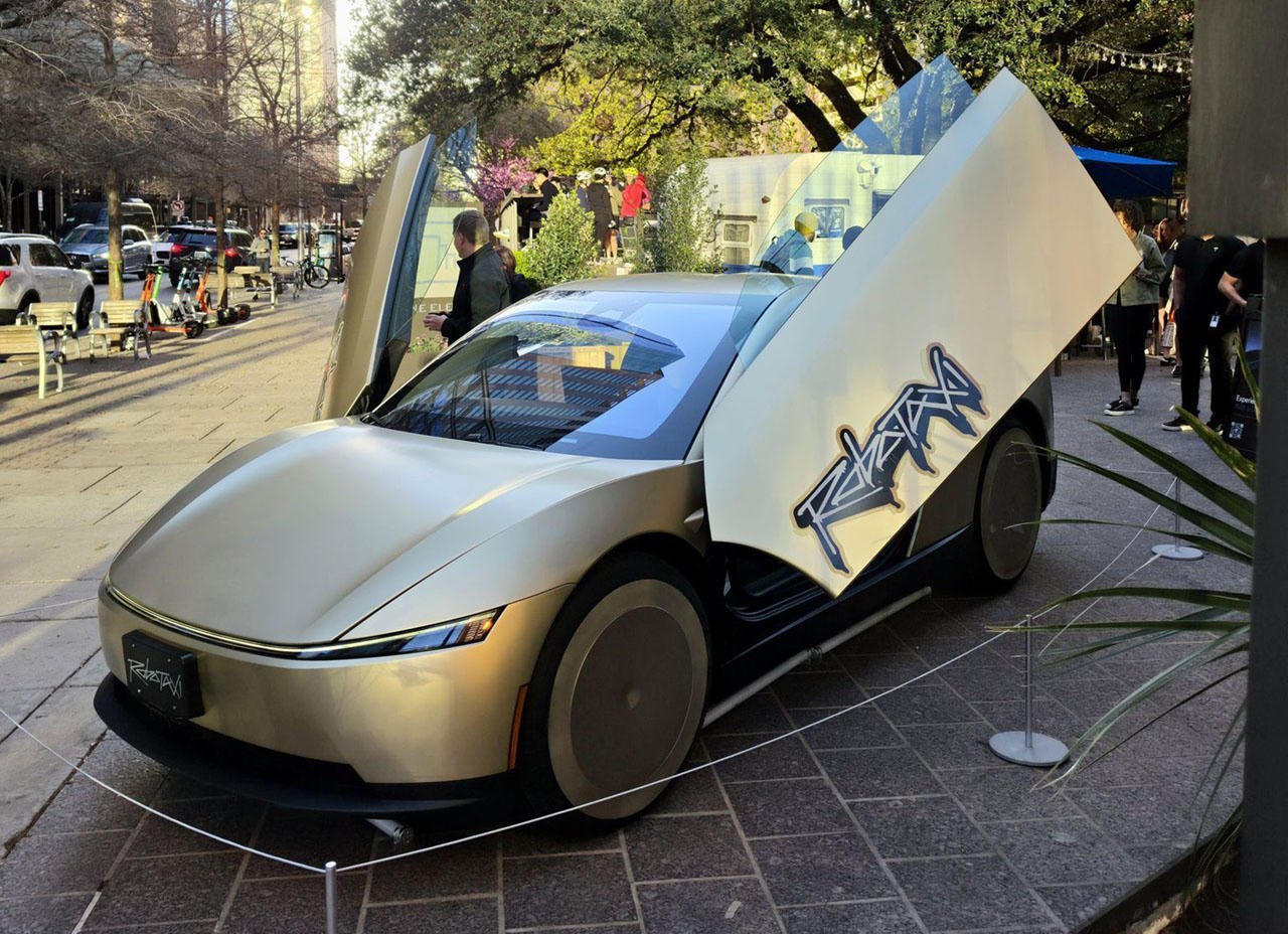 Złoty Tesla Cybercab z otwartymi drzwiami motylowymi, bez kierownicy