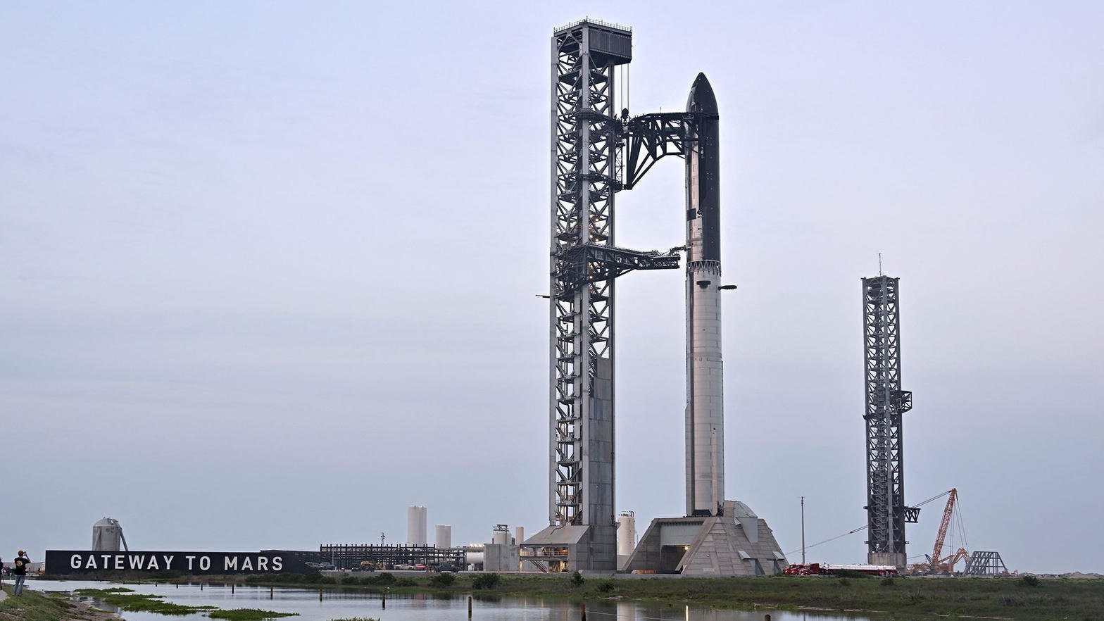 Starship na wieży obok napisu Gateway to Mars w Starbase
