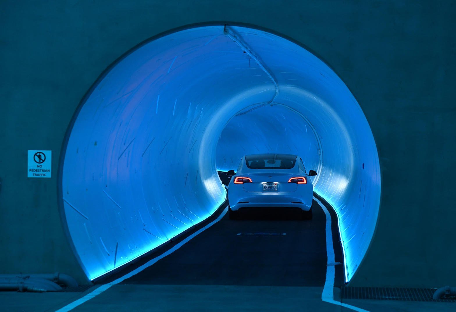 Biała Tesla w niebiesko podświetlonym tunelu Vegas Loop